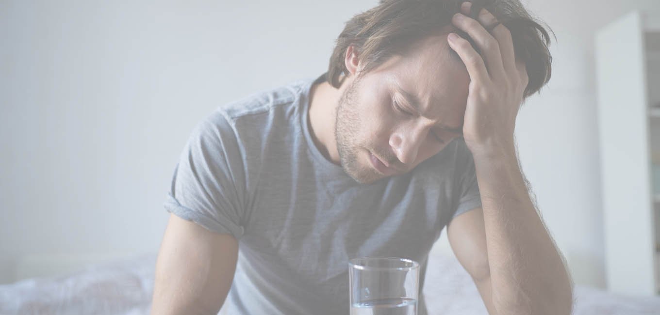 Мужчина держит в руке стакан воды